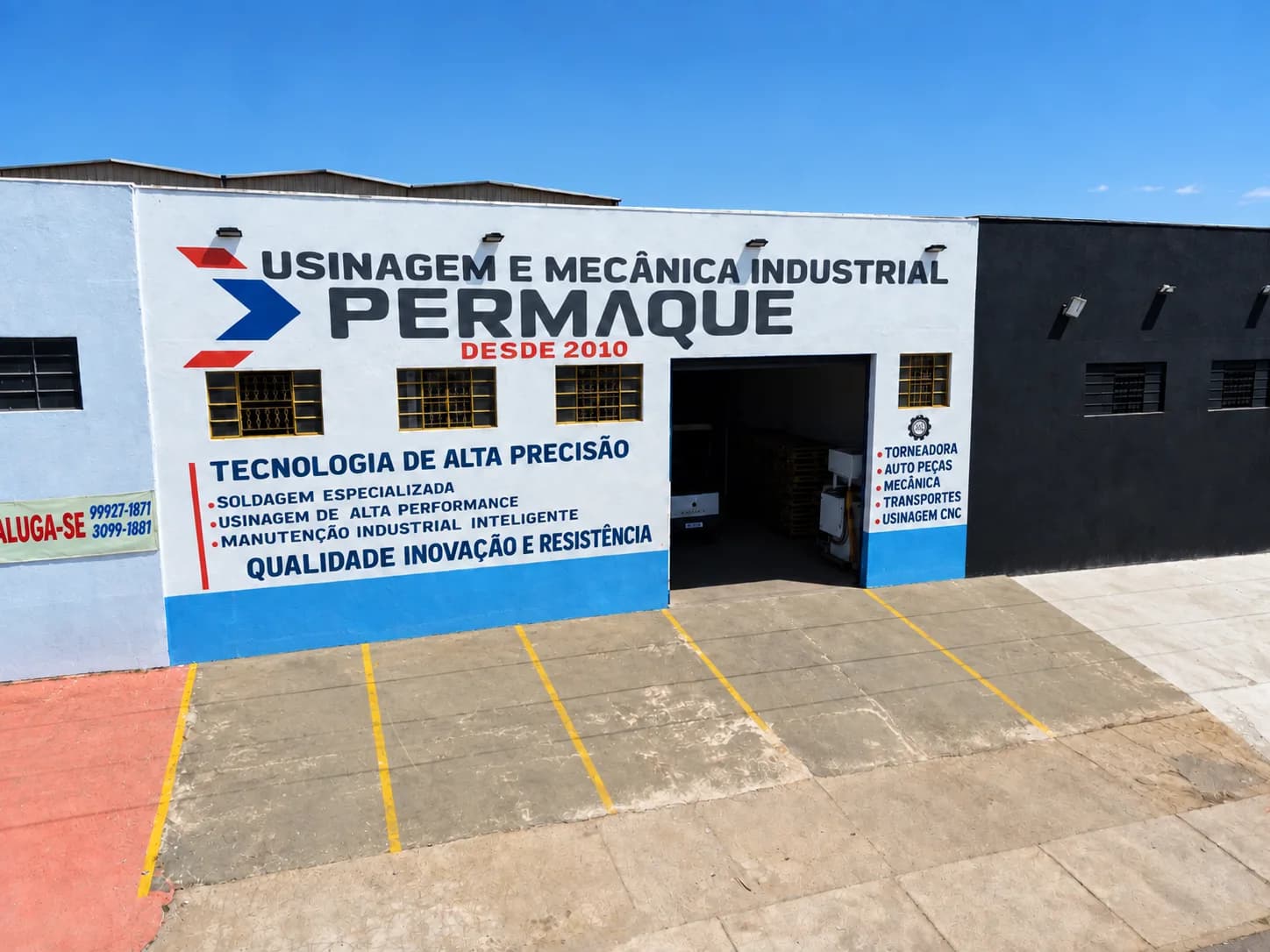 Fachada da unidade da Permaque em Anápolis, com o letreiro "Usinagem e Mecânica Industrial Permaque — desde 2010", o portão do galpão aberto e o pátio pavimentado à frente