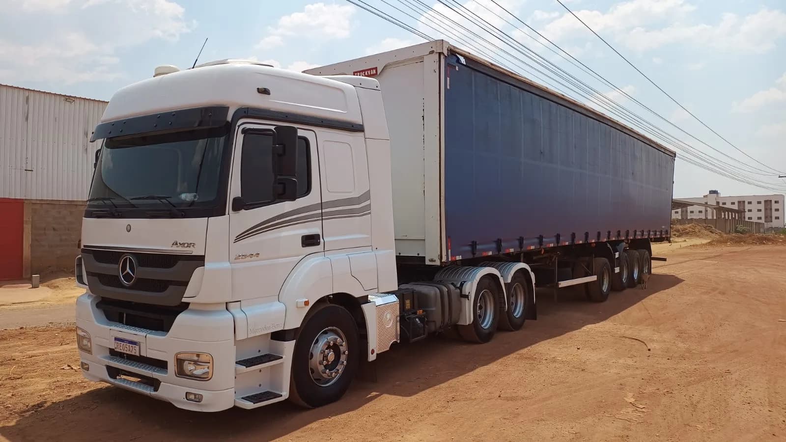 Conjunto Mercedes-Benz Axor branco acoplado a carreta com carroceria sider